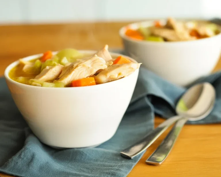 Bowl of easy chicken and dumplings with vegetables and tender chicken in creamy broth